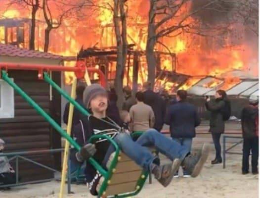Невозмутимый мальчик на качелях на фоне бушующего пожара стал новым мемом - nur.kz - Ноябрьск