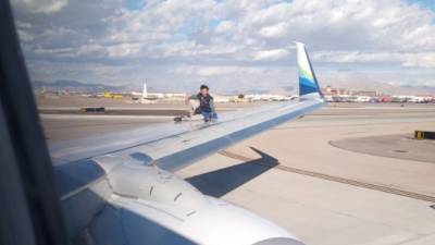 Мужчина забрался на крыло самолета, готовившегося к вылету из аэропорта. Видео - vesti.ru - США - штат Орегон - state Alaska