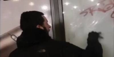 Молодой человек в центре Киева посреди дня расписывал остановку общественного транспорта - ТЕЛЕГРАФ - telegraf.com.ua - Киев