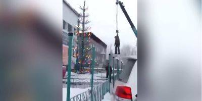 В Якутии коммунальщика подвесили на кране, чтобы украсить новогоднюю елку — видео - nv.ua - Россия - Украина - респ. Саха - Покровск - респ. Хакасия